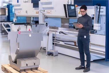 An employee uses omlox to find a workpiece on a pallet. Positioning technologies and products from different vendors can be combined via this uniform standard.